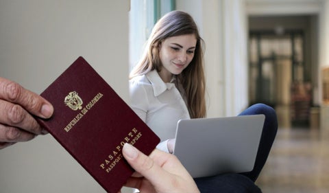 Mujer con computador y el pasaporte