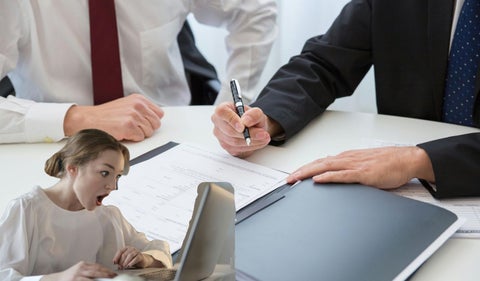 Personas firmando contratos y una mujer sorprendida