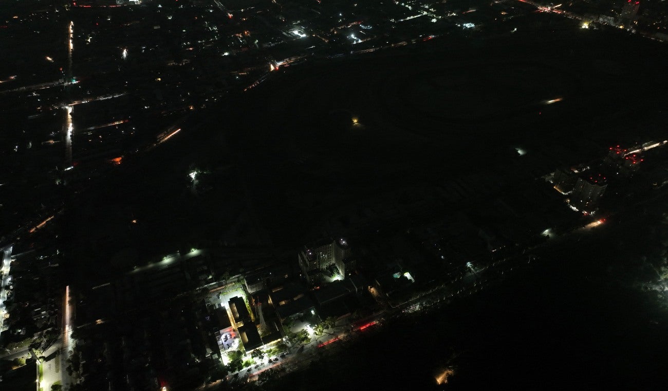 Esta vista aérea muestra la ciudad parcialmente iluminada durante un apagón en Santiago el 25 de febrero de 2025.