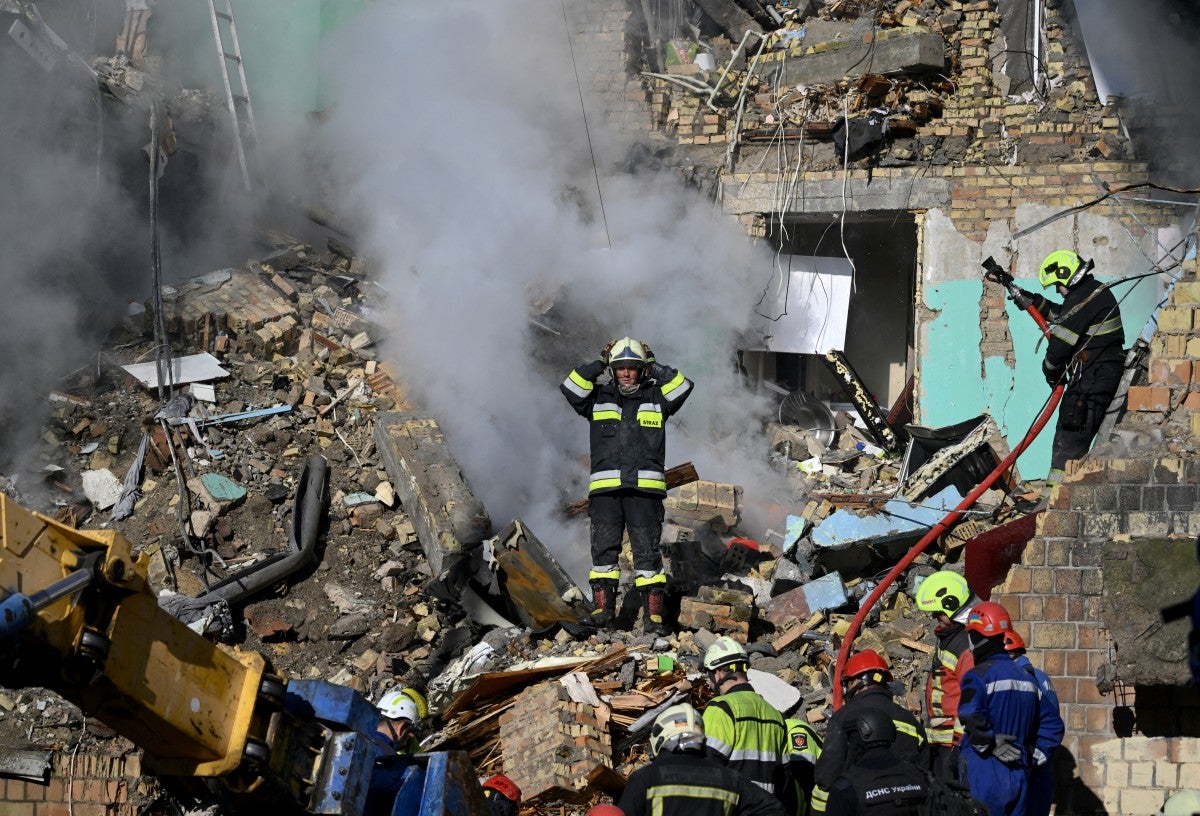 Rescatistas atienden en un edificio destruido la emergencia que provocó un ataque de Rusia a Kiev.