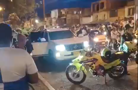 Captura de pantalla de un video difundido en redes sociales que muestra a una camioneta de alta gama afectada por disparos e inspeccionada por la Policía y por testigos.