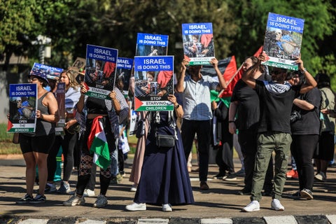 Activistas cantan y sostienen pancartas durante una manifestación frente a la embajada de Israel en Pretoria el 3 de octubre de 2025.