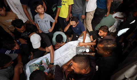Equipos de rescate palestinos recuperan cuerpos tras el ataque israelí contra un autobús que transportaba desplazados en el barrio de Zeitún, Gaza.