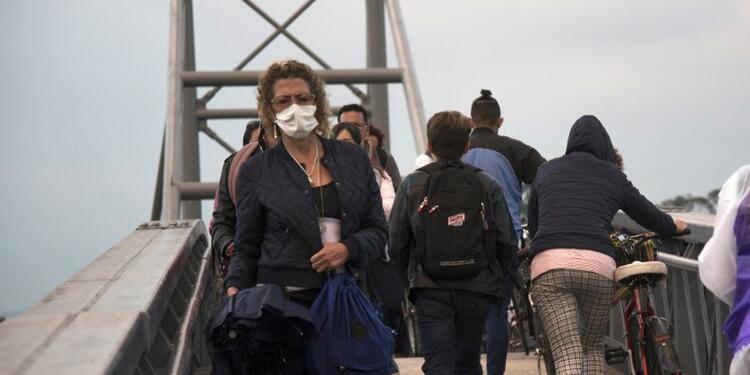 Mujer cruza puente peatonal con tapabocas Mujer cruza puente peatonal con tapabocas