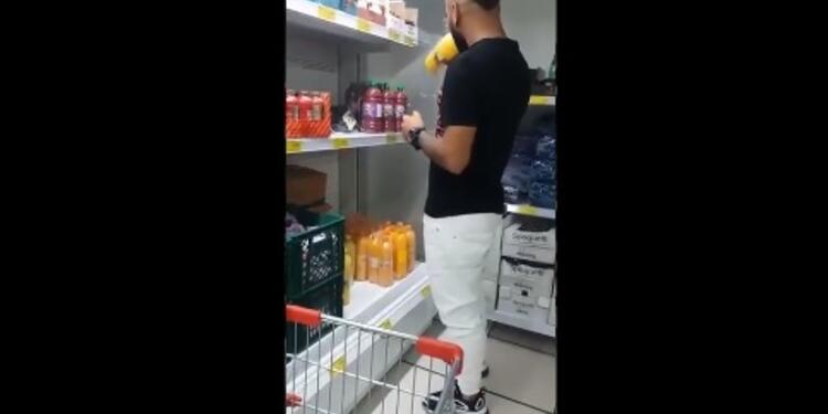 Hombre tomando de varias botellas de jugo en una tienda D1.