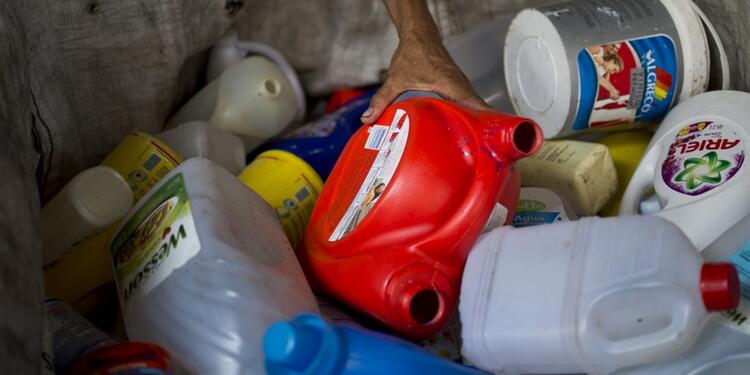 Hombre recolecta botellas de plástico en un depósito de reciclaje en Cali.
