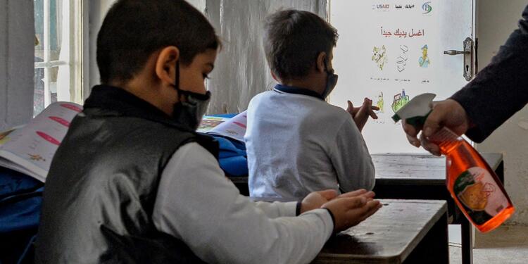 Niños en colegios desinfectándose las manos.