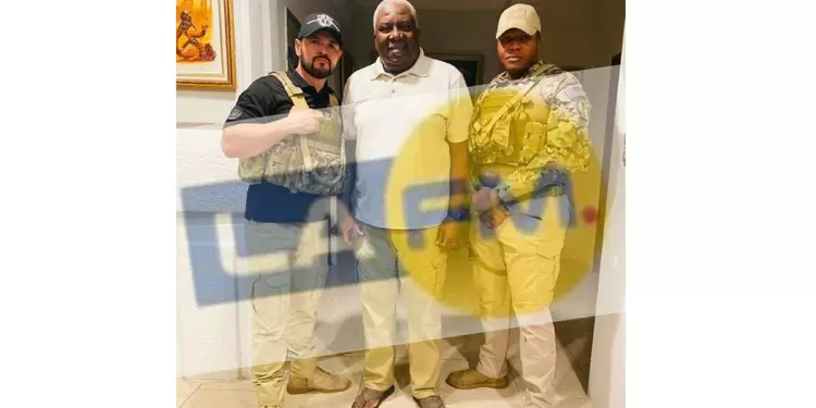 Emanuel Sanon viste una camiseta blanca y posa junto a dos militares Emanuel Sanon viste una camiseta blanca y posa junto a dos militares