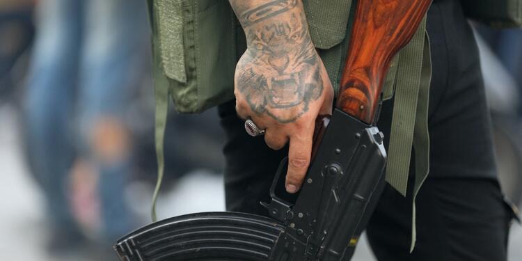 Miembro de Hezbolá sostiene su arma durante un funeral por muerte de terroristas Miembro de Hezbolá sostiene su arma durante un funeral por muerte de terroristas