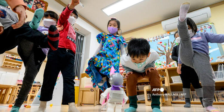 Niños de guardería juegan con el robot Alpha Mini Niños de guardería juegan con el robot Alpha Mini