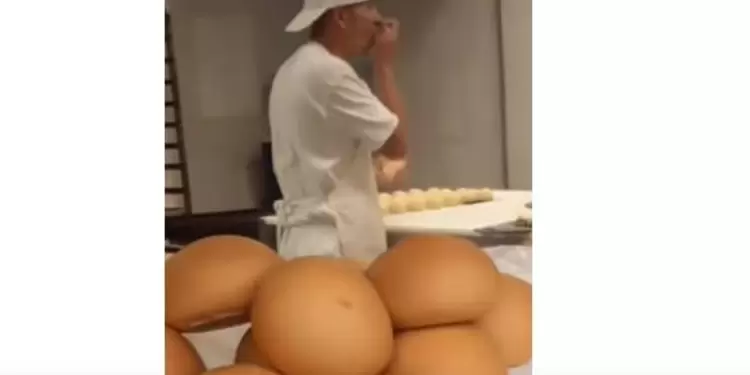 Graban panadero lamiendo la masa antes de meterla al horno