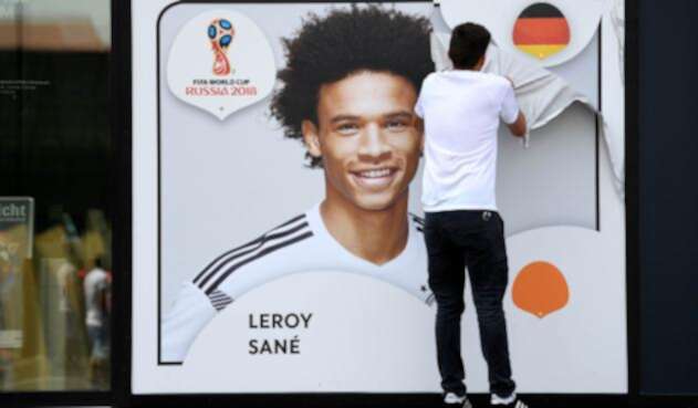 Un empleado de la Federación Alemana de Fútbol retira el afiche de Leroy Sané, en Dortmund