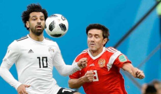 El egipcio Mohamed Salah defiende un balón con Yuri Shirkov de Rusia El egipcio Mohamed Salah defiende un balón con Yuri Shirkov de Rusia