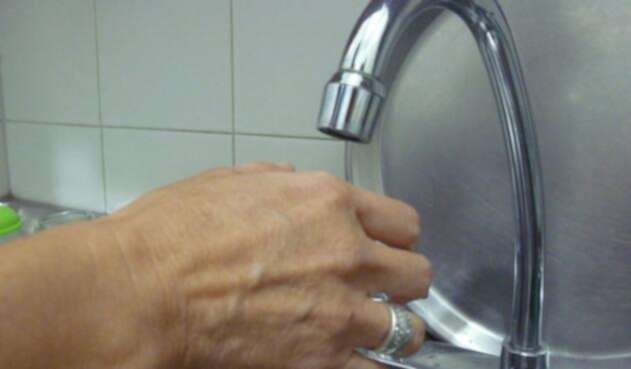 Una persona usando el lavaplatos de su hogar Una persona usando el lavaplatos de su hogar