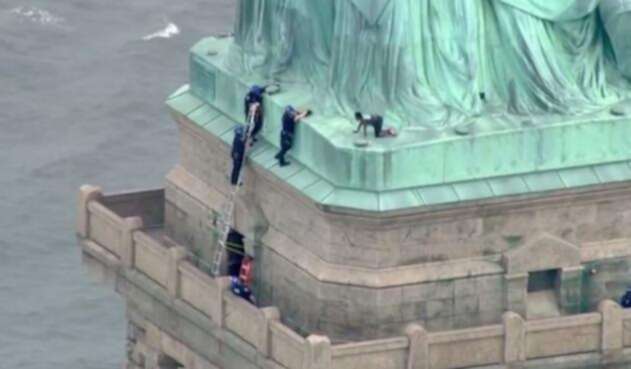 La mujer se encuentra en la base de la Estatua de la Libertad.