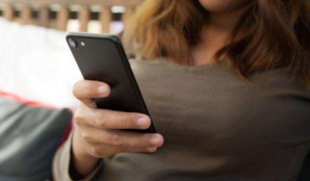 Mujer consultando su teléfono celular