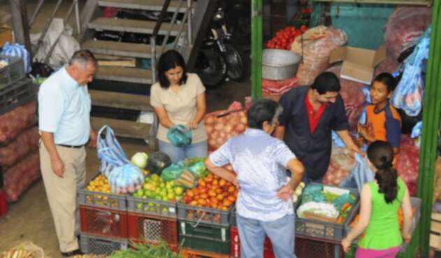 Consumidores en un mercado comprando productos básicos de la canasta familiar