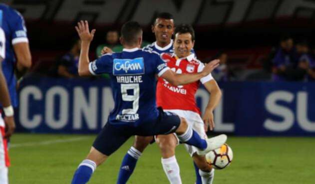 Diego Güastavino (Santa Fe) ante la marca de dos jugadores de Millonarios