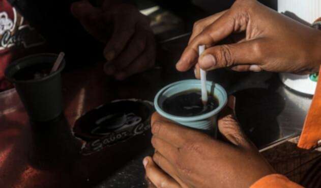 Una mujer tomando café en el Parque Berrío, en Medellín