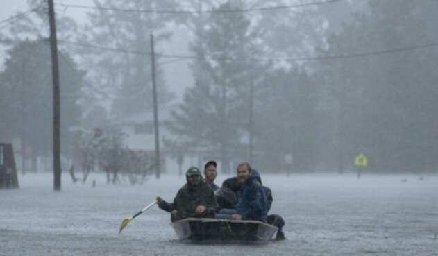 Personas navegando sobre las aguas que dejó Florence