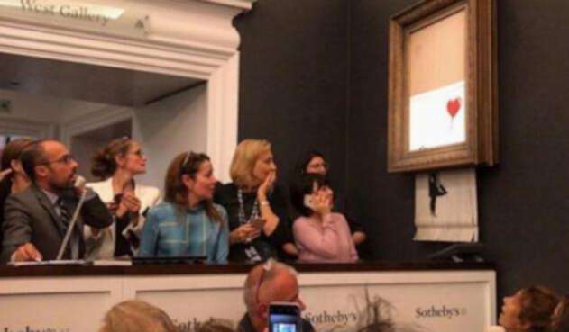 Obra de Banksy se autodestruye después de ser subastada.