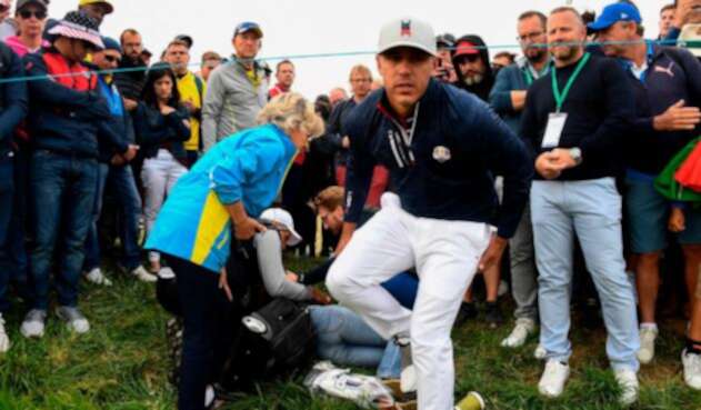 El golfista Brooks Koepka tratar de auxiliar a una espectadora que recibió el golpe de una bola en su ojo derecho