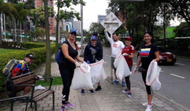 Venezolanos recogen basuras en Medellín.