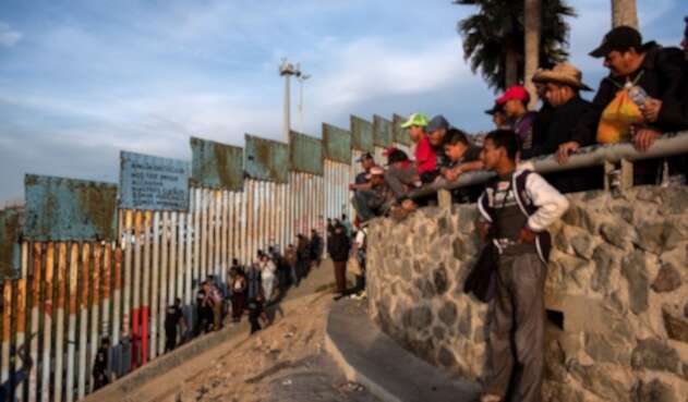 Migrantes centroamericanos en muro de Estados Unidos