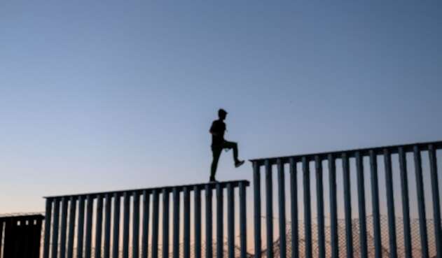 Migrantes en el muro entre México y Estados Unidos