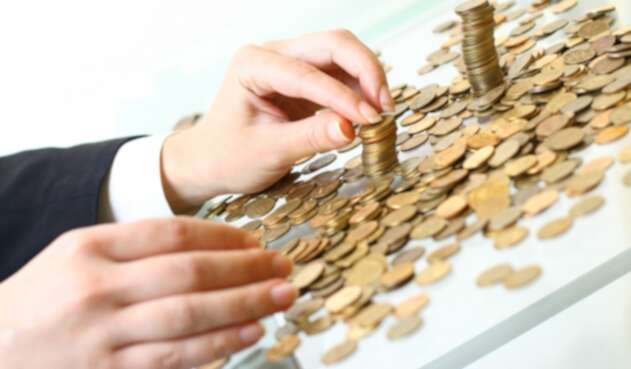 Una persona contando sus ahorros en moneda