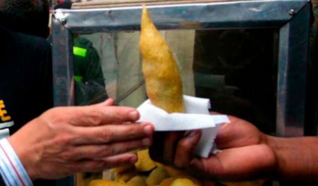 Ciudadano comprando una empanada en Bogotá