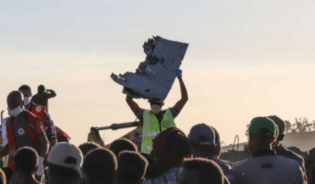 Una persona sujeta una parte del avión siniestrado en Bishoftu, en inmediaciones de Addis Ababa, en Etiopía