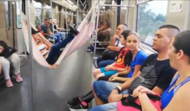 Un hombre cuelga una hamaca en pleno vagón del Metro de Medellín.