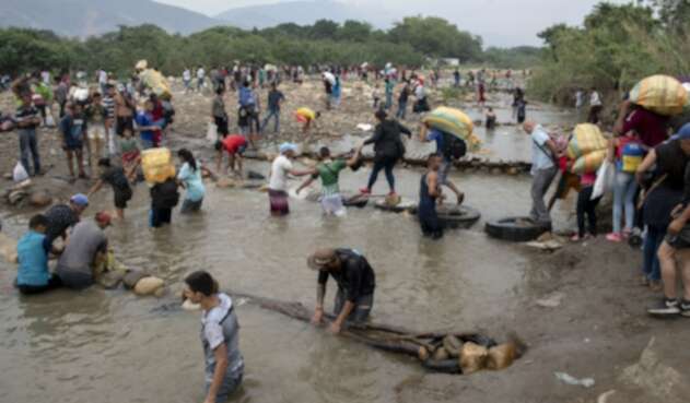 Venezolanos cruzando la frontera por el río Venezolanos cruzando la frontera por el río