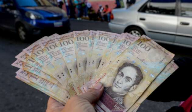 Un ciudadano venezolano expone bolívares, moneda oficial, en las calles de Caracas