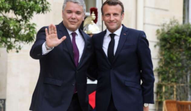 El presidente francés Emmanuel Macron (d) posa con el presidente Ivan Duque (i).