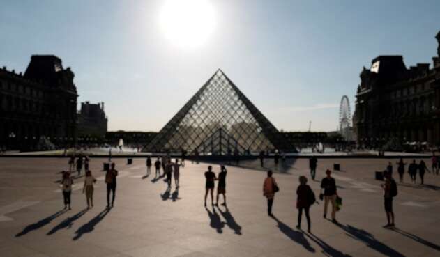 Turistas visitando la Pirámide del Museo del Louvre, en París (Francia), el 3 de julio de 2019