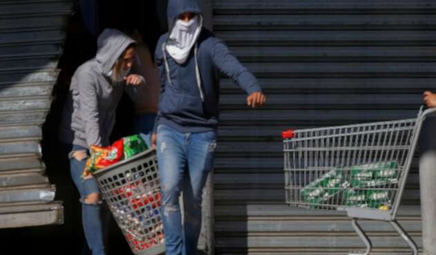 Manifestantes en Chile hurtando un supermercado