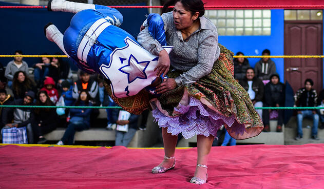 Con falda ondulante de brillantes, las luchadoras se lanzan al combate.
