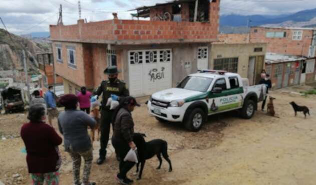 Policía en Bogotá llevando comida a perros y gatos.