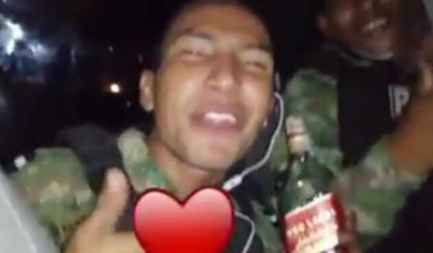 El uniformado enseñó en el video la botella de whisky.