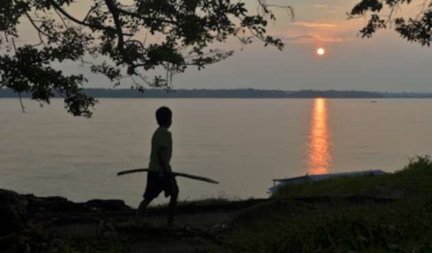 Un niño indígena colombiano camina a orillas del río Amazonas.