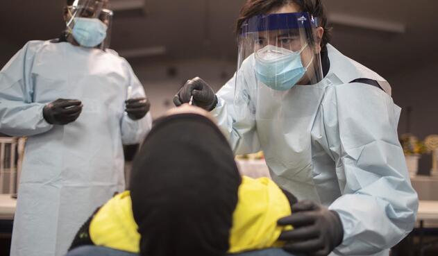 Trabajadores de la salud hacen la prueba a una mujer en Estados Unidos Trabajadores de la salud hacen la prueba a una mujer en Estados Unidos