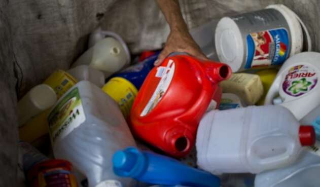 Hombre recolecta botellas de plástico en un depósito de reciclaje en Cali.