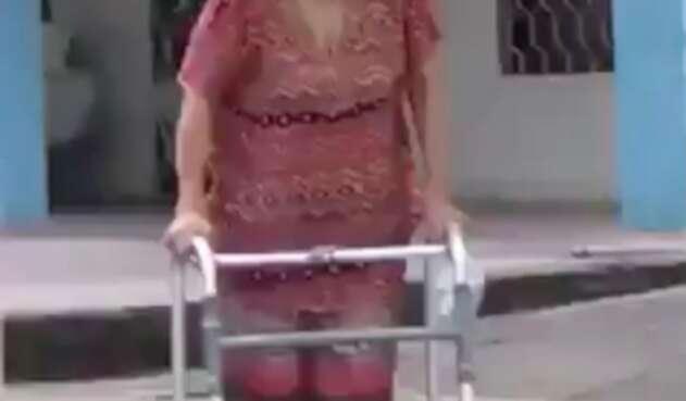 La mujer utiliza un tubo de PVC para poder caminar.