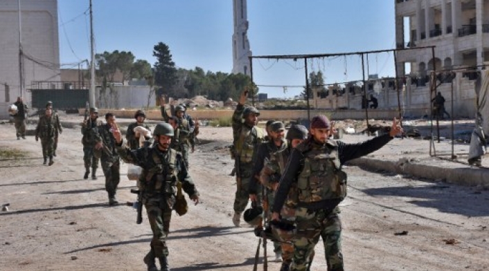 Syrian pro-government soldiers gesture as they walk down the road in the '3000' apartment block area, in al-Hamdaniyah, in ea...