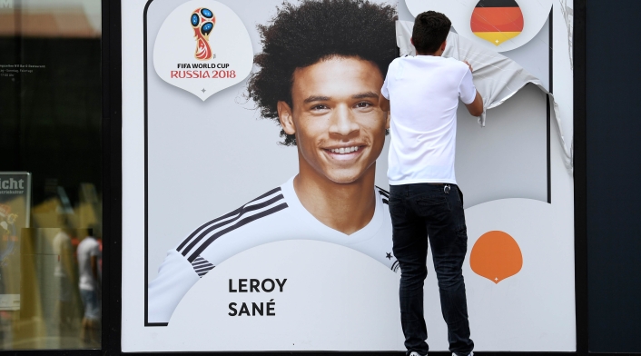 Un empleado de la Federación Alemana de Fútbol retira el afiche de Leroy Sané, en Dortmund