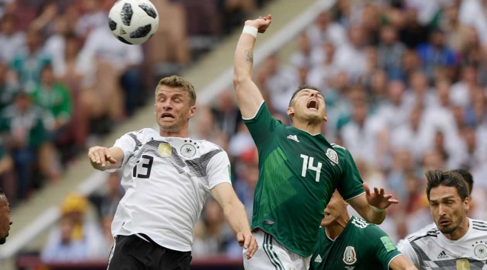 El alemán Thomas Müller disputa un balón con Javier Hernández de México