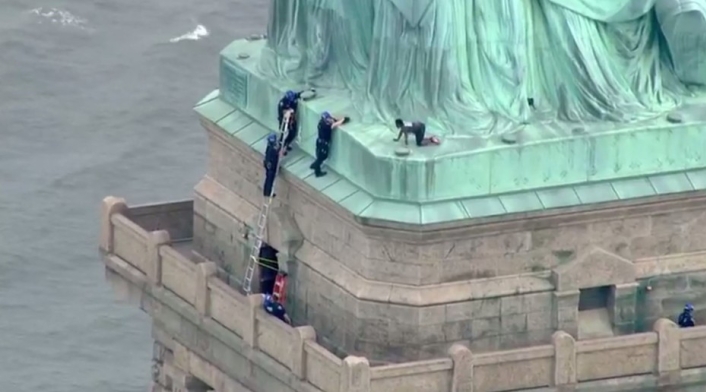 La mujer se encuentra en la base de la Estatua de la Libertad.