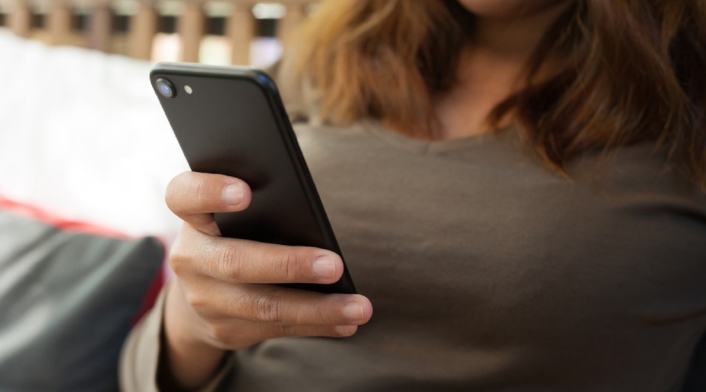 Mujer consultando su teléfono celular